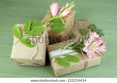 Natural style handcrafted gift boxes with fresh plants and rustic twine, on wooden