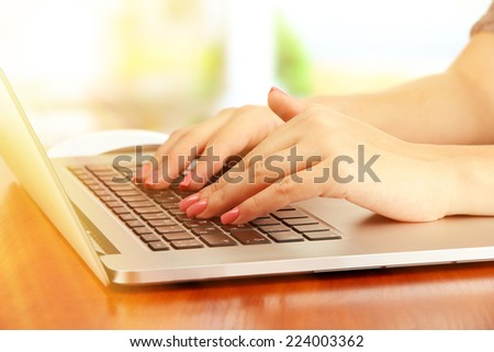 Female hands on laptop, close-up