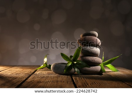 Spa stones and bamboo on wooden table on dark background