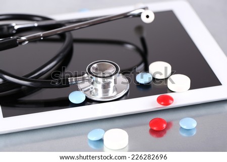 Stethoscope, pills, PC tablet on light background. medicine concept
