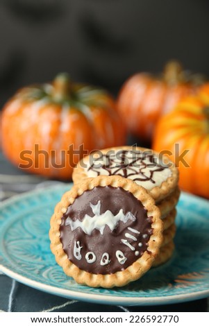 Tasty Halloween cookies on plate, on decorative spiderweb