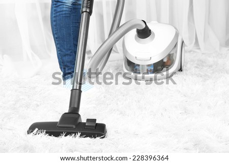 Woman with vacuum cleaner in room