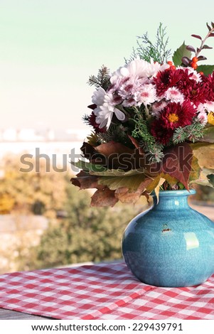 Flower bouquet in blue vase on table on natural background