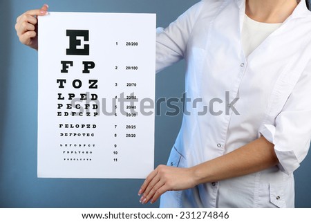Health care, medicine and vision concept - woman with eye chart on color background