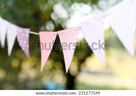 Colorful bunting flags against green trees