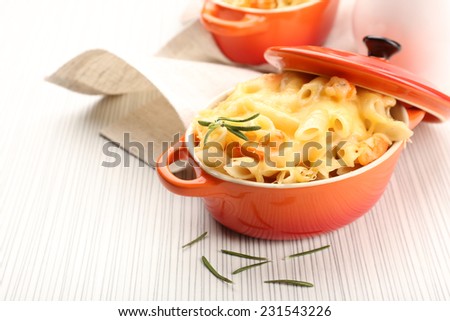 Pasta baked with shrimps and cheese in ceramic pot