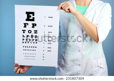 Health care, medicine and vision concept - woman with eye chart on color background
