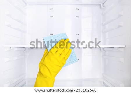 Woman\'s hand washing refrigerator with duster