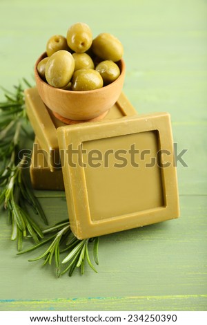 Bars of natural soap with rosemary and olive oil on wooden background