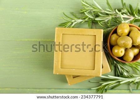 Bars of natural soap with rosemary and olive oil on wooden background