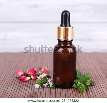 Essential oil with different medicine plants, on wooden background