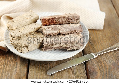 Two kinds of sunflower halva on plate, on wooden background