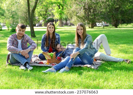 Happy friends on picnic in park