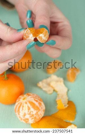 Hands holding ripe tangerine, close up
