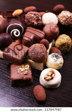 Group of sweet chocolate truffles on the dark wooden smooth background