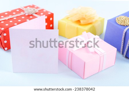 Colorful boxes with greeting card on blue uneven background
