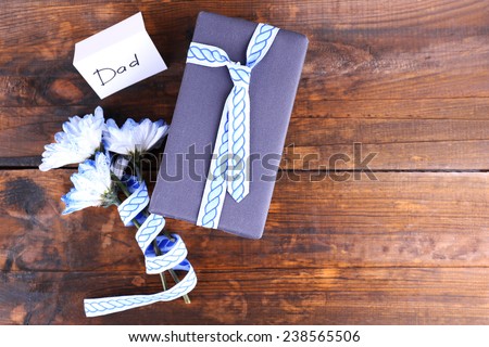 Happy Father\'s Day with gift box, ribbon, bouquet of flowers and greeting card on wooden background
