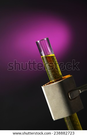 Laboratory glass test tube filled  color liquid held in specialized  clamp during  scientific experiment