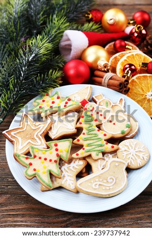 gingerbread cookies on plate with Christmas decoration on wooden table background