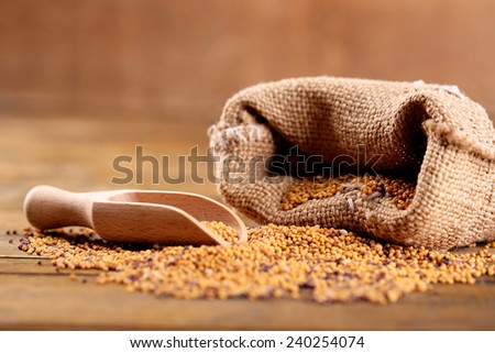 Mustard seeds in bag on  wooden background