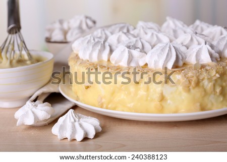 Tasty homemade meringue cake on wooden table, on light background