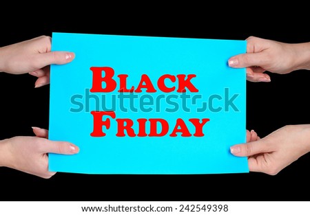 Women\'s hands holding advertising with Black Friday text on it isolated on black