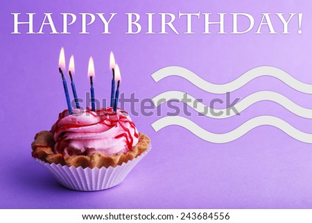 Cake with birthday candles on purple background