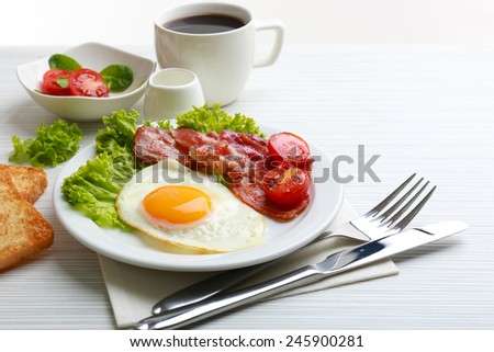 Bacon and eggs on color wooden table background