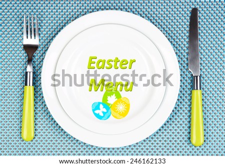 Plate with text Easter Menu, fork and knife on tablecloth background