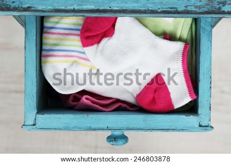 Socks in color drawer on wooden floor background