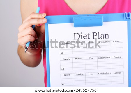 Sports trainer with personal training program on grey background