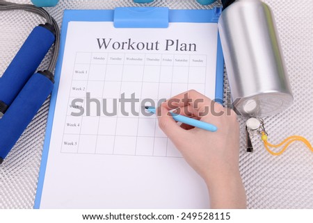 Sports trainer amounts to workout plan close-up