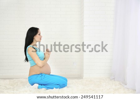 Young pregnant woman on light background. Yoga for pregnant women concept