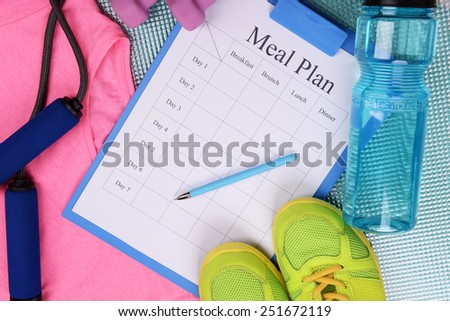 Meal plan and sports equipment top view close-up