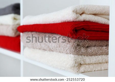 Colorful towels on shelf of rack background
