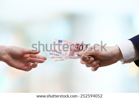 Businessman giving money on light blurred background