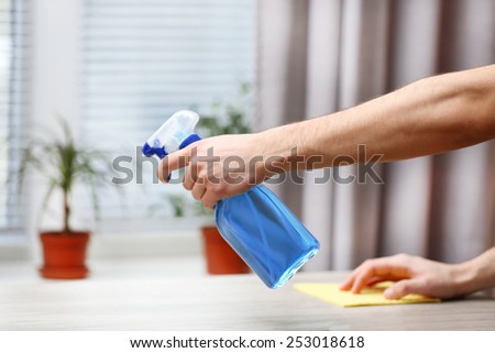Male hands with sprayer and rag wash windowsill on window background