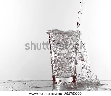 Water pouring in glass isolated on white