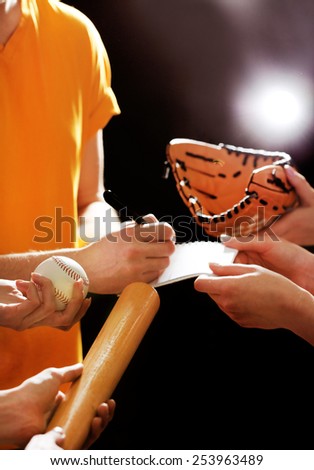 Autographs by baseball star on black and lights background