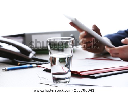 Businessman working at table in office on white blurred background