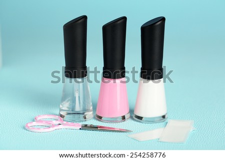 French manicure set with white tip polish, and top coat shine applicator for nails on color background