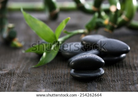 Stack of black sea paddles with bamboo trunks on rustic wooden background