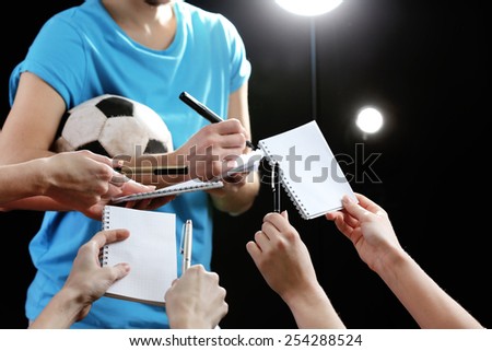 Autographs by football star on black and lights background
