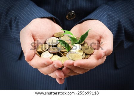 Male hands with coins and plant close-up