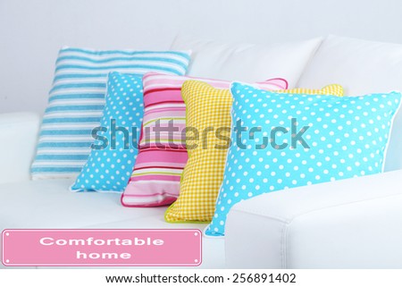 White sofa with colorful pillows on wall background, Comfortable Home concept