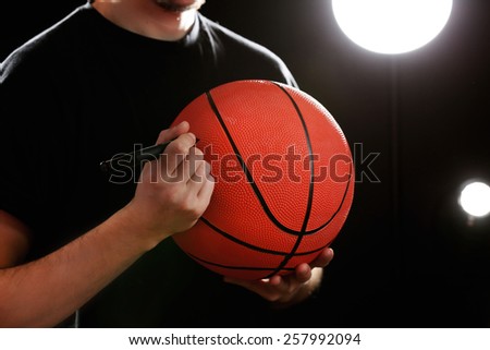 Autographs by basketball star on black and lights background