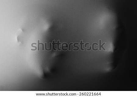 Human faces pressing through fabric as horror background