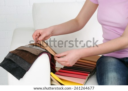 Woman sitting on sofa and chooses scraps of colored tissue