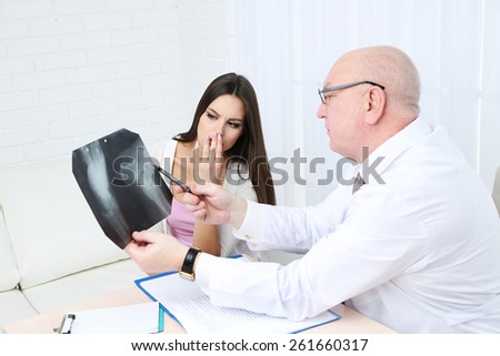 Doctor receiving X-ray results in office on white background