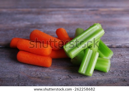Sticks of celery and carrot on rustic wooden background